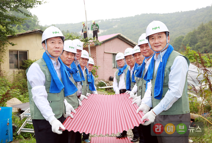 6일 경남 창원시 진해구 용원동에서 열린 '사랑의 집 고치기' 농가희망봉사단 봉사활동에서 김성찬 국회의원(사진 오른쪽), 허식 농협중앙회 부회장(사진 왼쪽)이 '사랑의 집 고치기' 봉사활동 참가자들과 함께 강판을 운반하며 노후주택의 지붕개량작업을 돕고있다.
