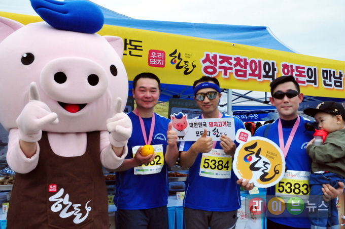 22일 경북 성주별고을운동장에서 열린 ‘제13회 성주참외전국마라톤대회’에서 참가자들이 한돈 캐릭터 ‘한도니’와 함께 마라톤 완주 기념 촬영을 하고 있다. 이번 대회에서 한돈자조금은 한돈 요리 시식회와 한돈요리 전시회 등을 운영하는 한편, 다양한 이벤트와 즐길거리를 마련해 참가자들에게 큰 호응을 얻었다.