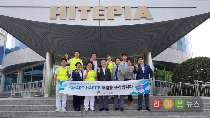 장기윤 원장, 박선희 이사, 김성곤 공장장을 포함한 HACCP인증원과 하이트진로 관계자들이 Smart HACCP 도입기념 촬영을 하고 있다.