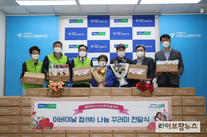 이성희 농협중앙회장(왼쪽에서 세번째)이 가정의 달을 맞아 4일 서울 서대문노인종합복지관(관장 탁우상, 오른쪽에서 두번째)을 방문하여 우리농산물 가공식품으로 구성된 꾸러미 선물을 전달하고 있다.