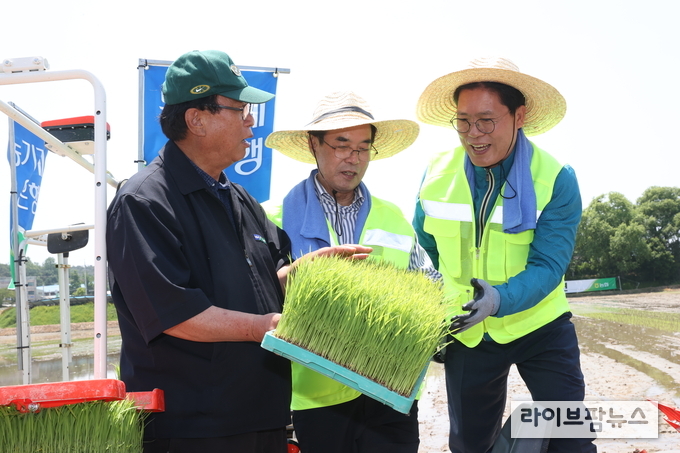 이성희(가운데) 농협중앙회장이 24일 경기도 이천시 율면농협 육모장에서 열린 '드문모심기 농작업대행 시연회'에 참석해 송석준(오른쪽) 국민의힘 의원, 율면농협 박병건 조합장(왼쪽)과 함께 반자율직진 이앙기를 이용해 모심기 시연을 하고 있다.