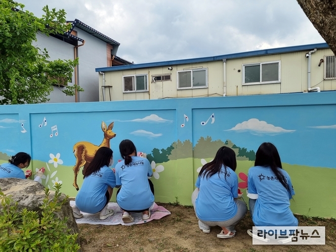 2022농촌재능나눔대학생캠프에 참여한 학생들이 첫 나눔활동으로 벽화그리기를 하고 있다.