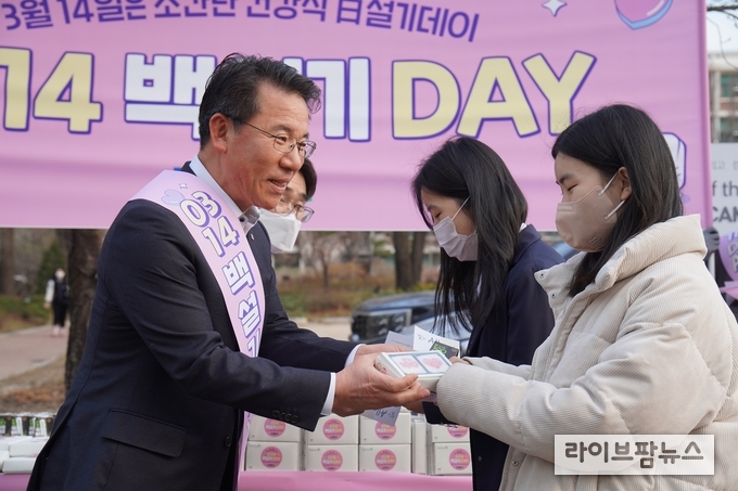 14일 백설기데이를 맞아 이화여자고등학교를 방문한 박서홍 농협경제지주 식품가공본부장(왼쪽)이 농업 분야 학생 관심도 증가와 농업 사랑 정신 고취를 위해 이화여고 재학생들에게 우리 쌀 백설기와 국산 쌀 홍보 리플렛을 배부하고 있다.
