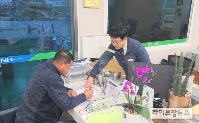 지난 23일 경북 성주 초전농협 자재판매장을 찾은 한 농업인이 농협 필름 담당자의 설명을 들으며 하우스필름 예약구매 신청서를 작성하고 있다.