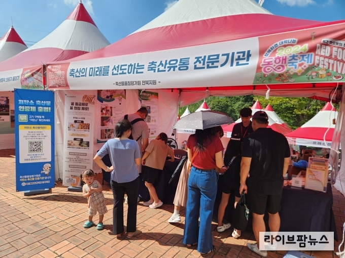축제를 참여한 관람객들이 축평원 전북지원 홍보부스에서 등급꿀 시음 및 저탄소축산물 인증제관련 설문조사에 참여하고 있다.