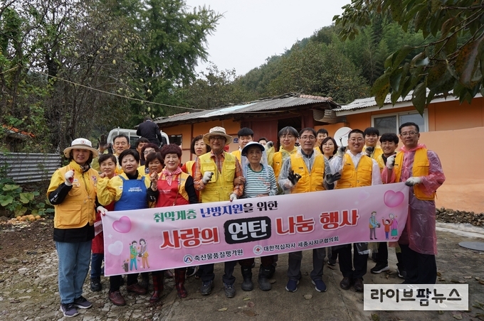 축산물품질평가원과 대한 적십자사봉사회가 ‘사랑의 연탄 나눔 행사’ 봉사 후 단체 사진을 촬영하고 있다.
