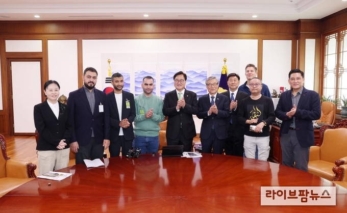 우원식 국회의장이 의장집무실에 '힌츠페터 국제보도상' 수상자들을 초청 기념촬영을 하고 있다(사진=국회의장실 제공)