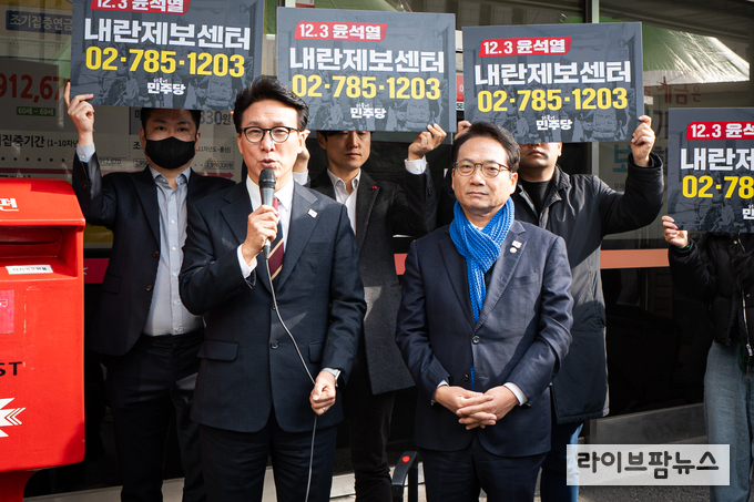 박선원 의원(오른쪽)이 더불어민주당 중앙당사 앞에서 제보센터 현판식을 갖고 있다.(사진=박선원의원실)