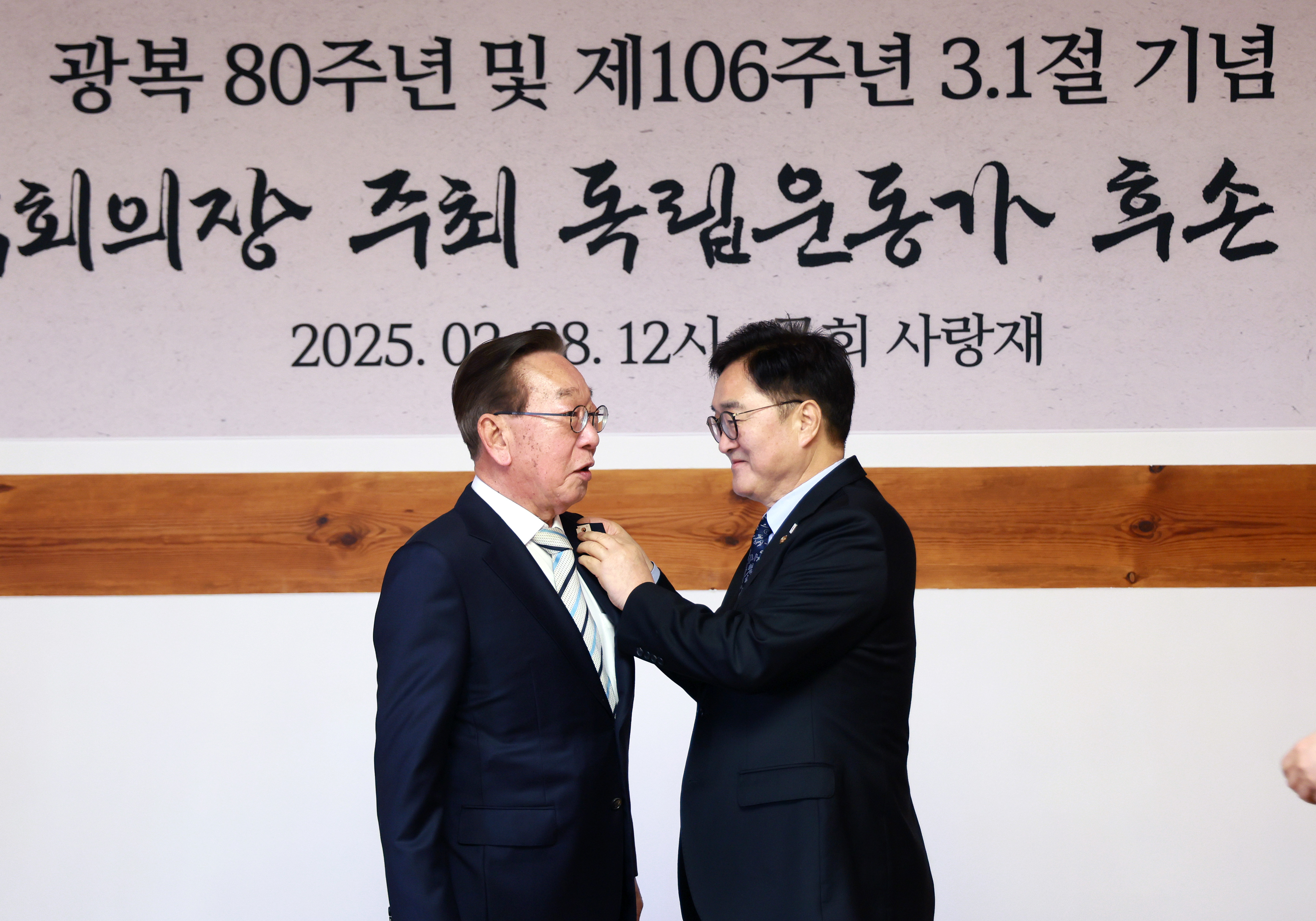 우원식 국회의장(오른쪽)이 진관사 태극기 문양 배지를 독립운동가 후손에게 달아주고 있다.(사진=국회)