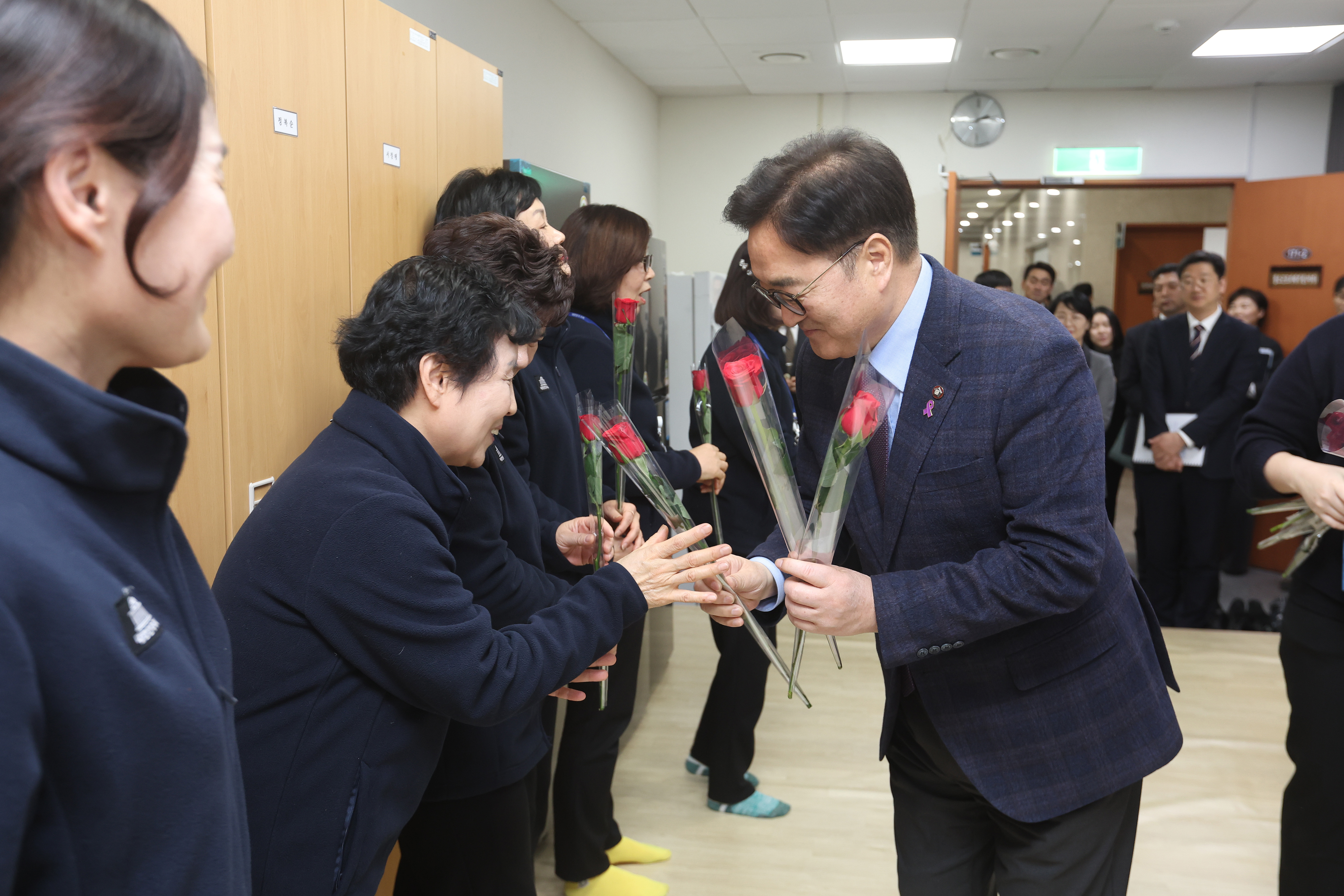 우원식 국회의장(왼쪽)이 세계 여성의 날을 맞아 국회사무처 여성노동자들에게 장미를 전달하고 있다.(사진=국회)