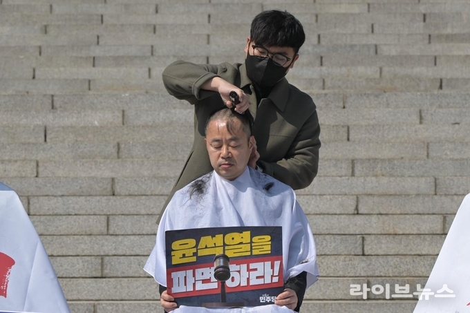 박홍배 국회의원이 국회 본청 계단 앞에서 삭발을 하고 있다.(사진=박홍배의원실)
