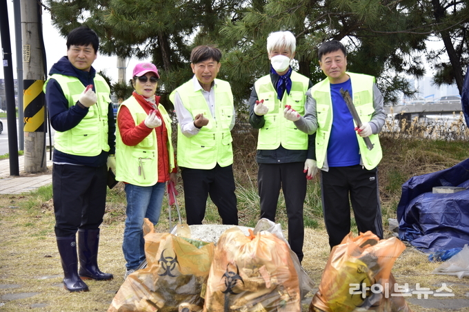 인천희망네트워크 윤계림 회장(가운데)과 회원들이 학익유수지에서 환경정화 활동을 마치고 기념촬영을 하고 있다.(사진=김현 기자)