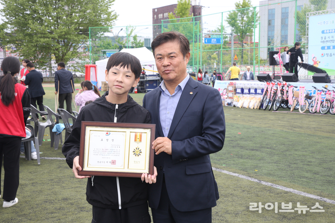 이학수 정읍시장이 정읍제일고등학교 운동장에서 열린 어린이날 기념행사에 참석해 모범 어린이에게 표창을 수여하고 기념촬영을 하고 있다.(사진=정읍시)