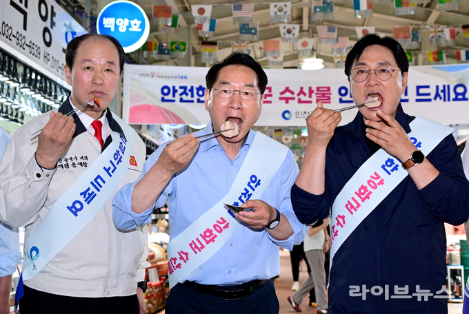 유정복 인천시장(가운데)이 강화군 외포항 수산물 직판장에서 수산물을 시식하고 있다.(사진=인천시)