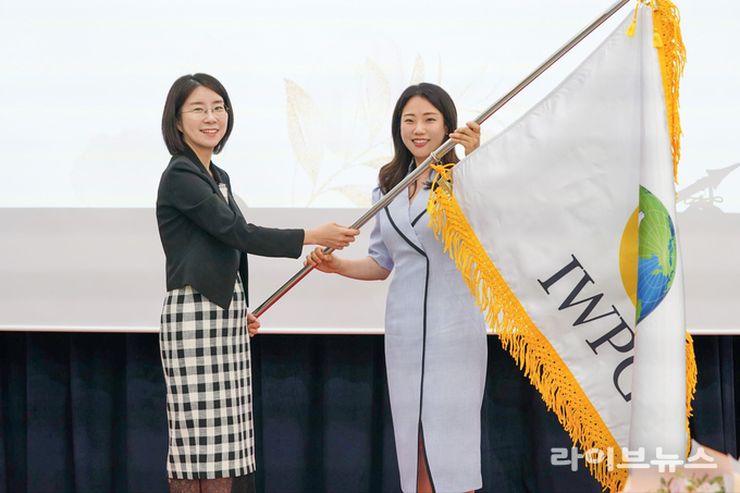 ㈔세계여성평화그룹(IWPG) 전나영 신임 대표(오른쪽)가 1일 서울 스페이스쉐어 서울중부센터에서 열린 대표이사 이·취임식에서 윤현숙 전 대표로부터 깃발을 전달받고 있다.(사진=IWPG)