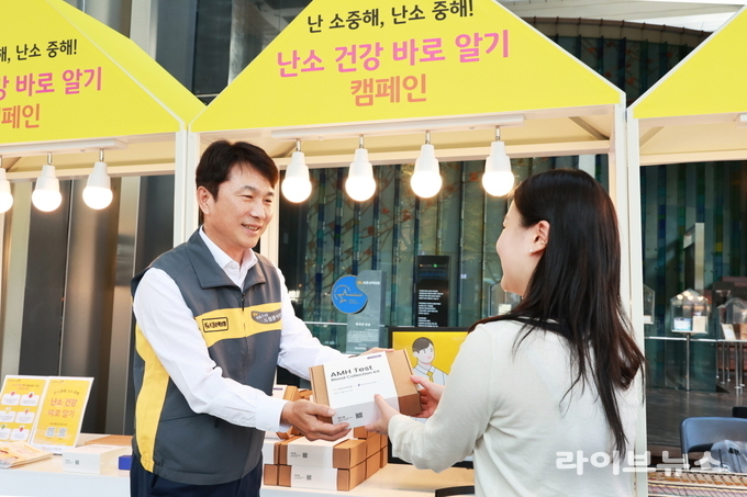 KB손해보험 구본욱 사장(왼쪽)이 행사에 참여한 여성에게 난소 나이 자가검사 진단 키트를 전달하고 있다.