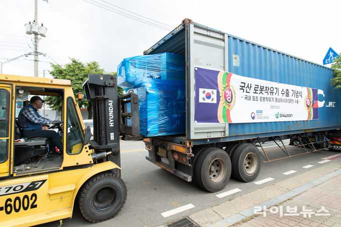 농촌진흥청 국립축산과학원이 8월 6일 인천광역시 서구에 위치한 민간기업 (주)다운과 공동 개발한 '데어리봇' 7대를 대만에 수출하기 위해 트레일러에 상차 하고 있다.<br>
<사진=농촌진흥청>