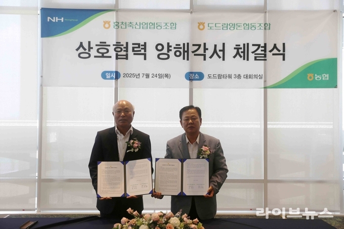 박광욱 도드람양돈농협 조합장(왼쪽)과 강문길 홍천축산농협 조합장(오른쪽)이 협약식 진행 이후 기념사진을 촬영하고 있다.