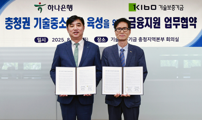 하나은행은 기술보증기금과 지난 19일 기술보증기금 충청지역본부에서 「충청권 기술 중소기업 대상 200억원 규모의 금융지원」을 위한 업무협약을 체결했다. 이날 협약식에 참석한 이동열 하나은행 충청영업그룹 부행장(사진 왼쪽)이 정대영 기술보증기금 충청지역본부장(사진 오른쪽)과 협약서를 들고 기념촬영을 하고 있다.