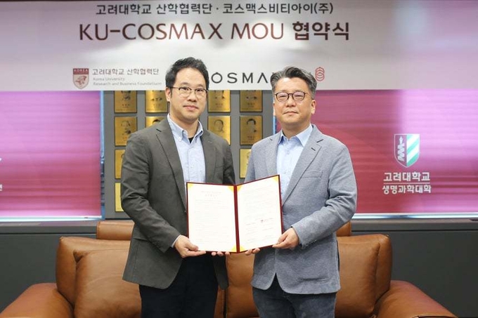 <em>울 성북구 고려대학교에서 열린 업무협약식에서 이동걸 코스맥스비티아이 MB랩장(왼쪽)과 이병천 고려대 산학협력단 부단장이 기념 촬영을 하고 있다.(코스맥스제공)</em>