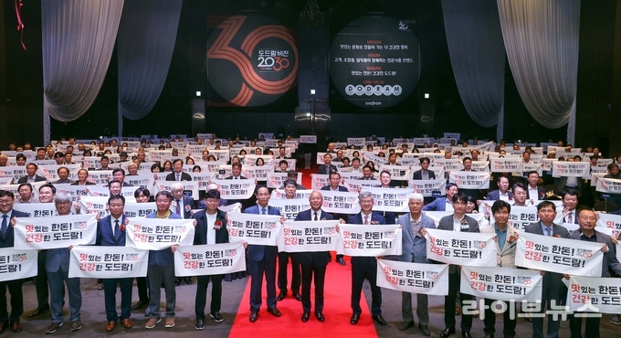 도드람 비전 2030 선포식에서 새로운 슬로건을 들고 있는 참석자 단체사진.