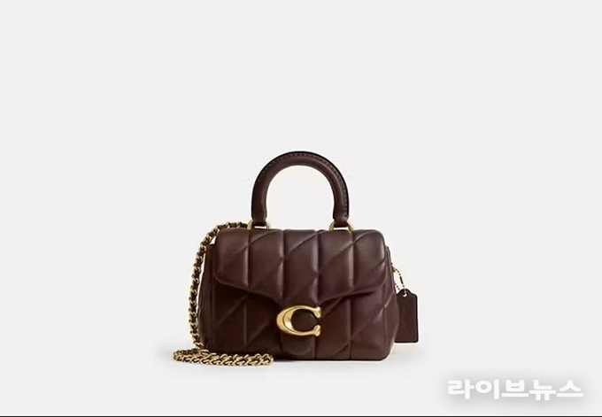 뉴트럴 톤 코디에 세련된 포인트를 주는 ‘태비 탑 핸들 백’.